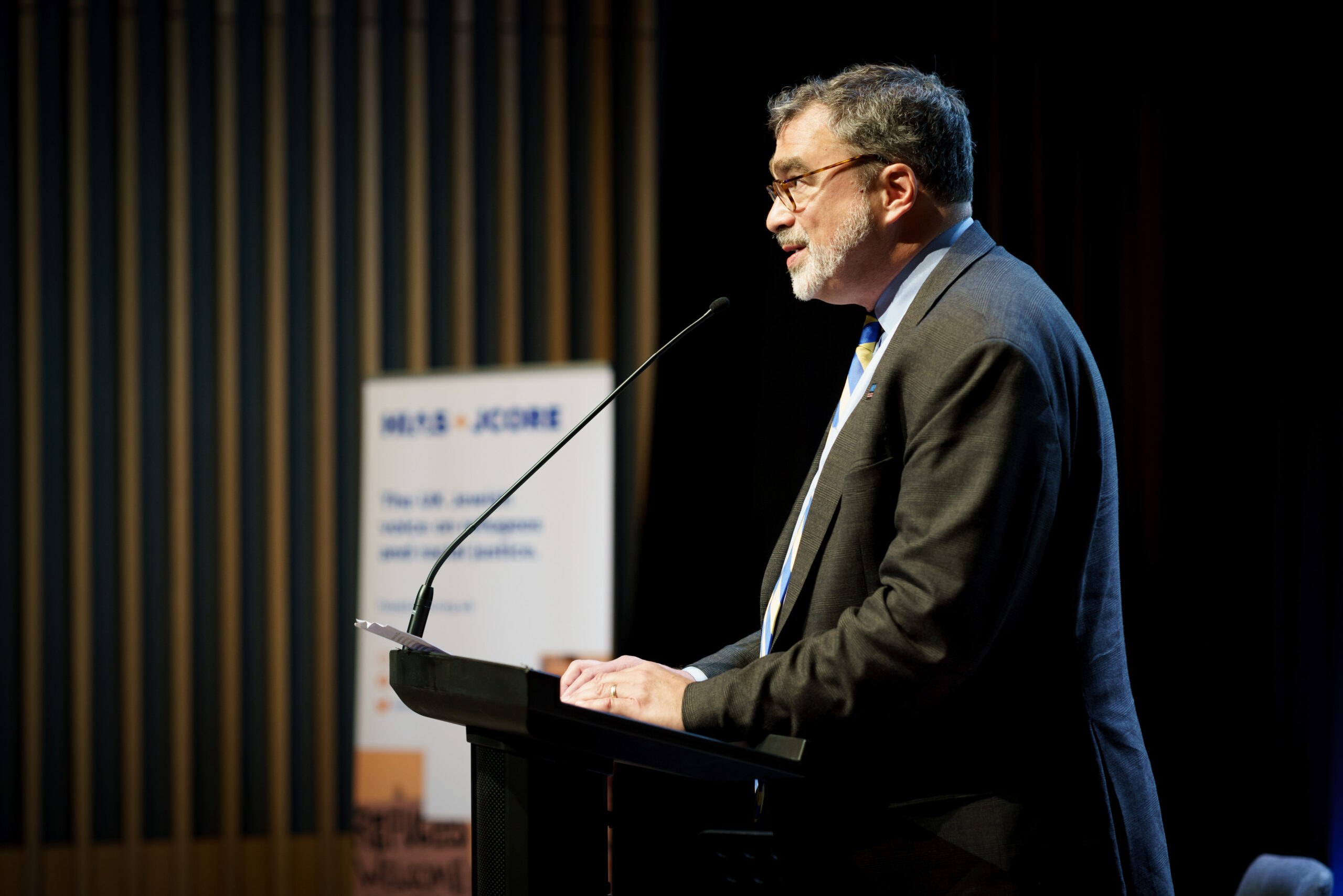 HIAS President and CEO Mark Hetfield speaks at the lectern at the launch event.